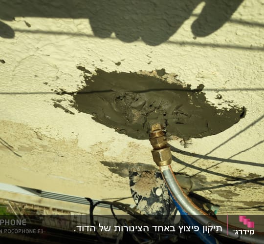 צינור מתכת מחובר לקיר עם טיח רטוב